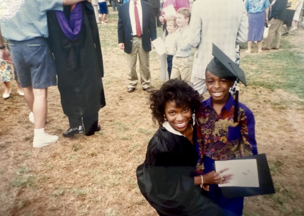 Byars and her son on her graduation day, posing for the camera as she holds her degree.