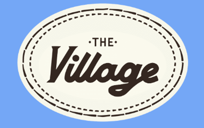A logo for "The Village" that is oval in shape.