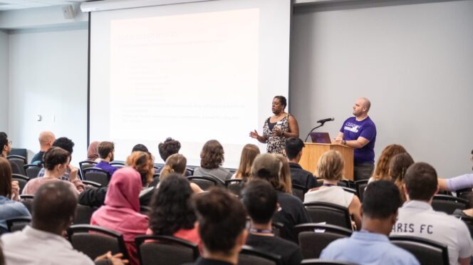 Birma Gainor and Jay Cooley of Counseling and Psychological Services address graduate students during orientation in August 2025