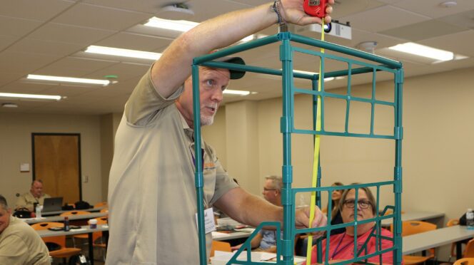 Paul Johnson of Dutchman Creek Middle School puts together a tomato trellis to use when he uses the CASE AgX curriculum to teach students about plant cultivation.
