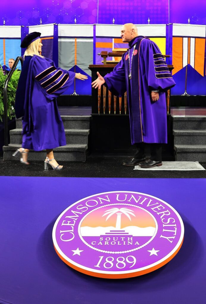 Angelica Solano shakes President Clement's hand as she crosses the stage during doctoral commencement.