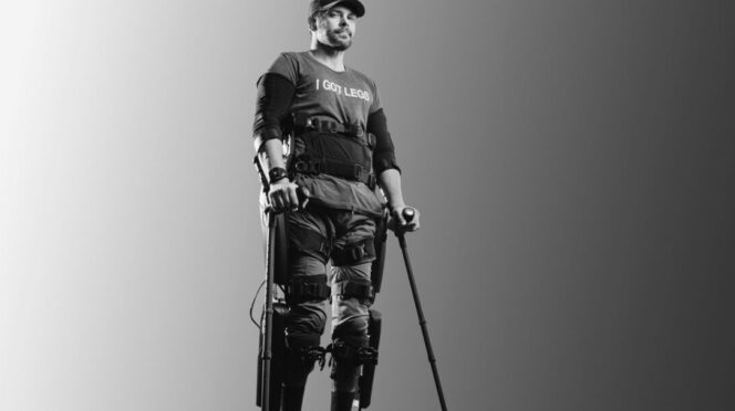 Adam Gortlisky standing with arm, leg and torso braces wearing a T-shirt that reads I GOT LEGS.