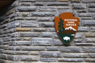 Insignia for the United States National Park Service on a visitors center on a rock wall.