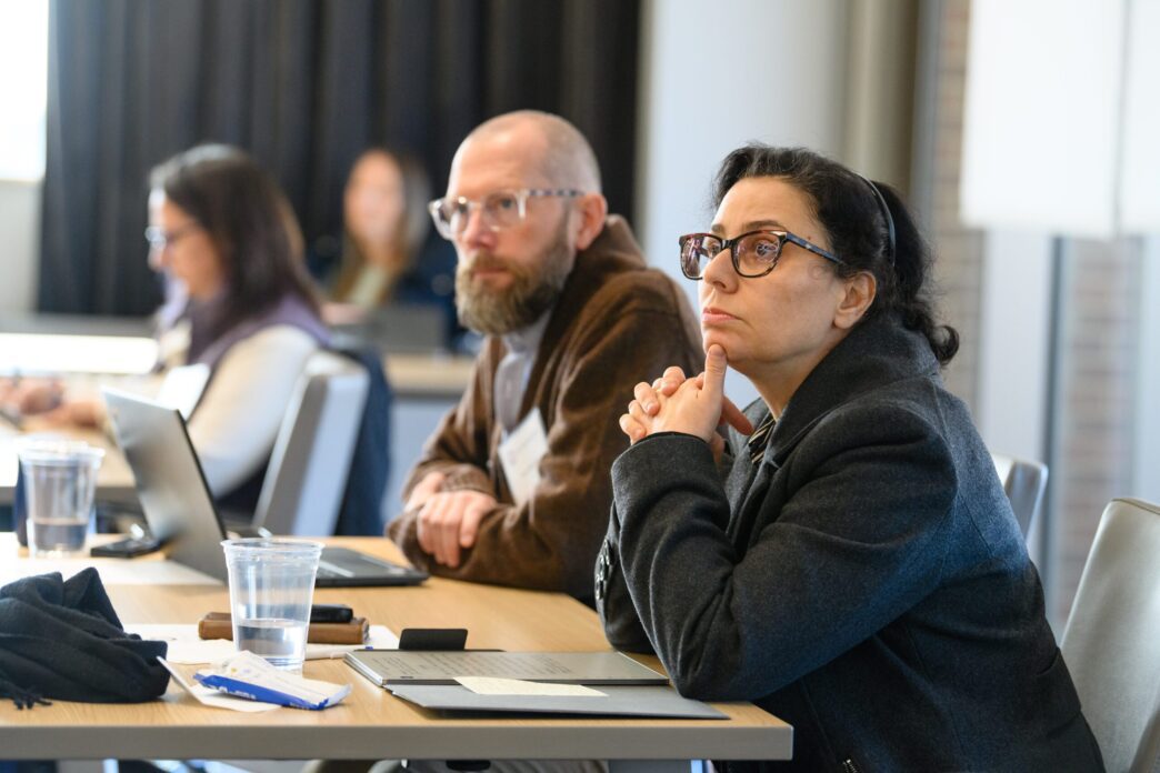 employees sitting at a table listen intently during a training