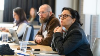employees sitting at a table listen intently during a training