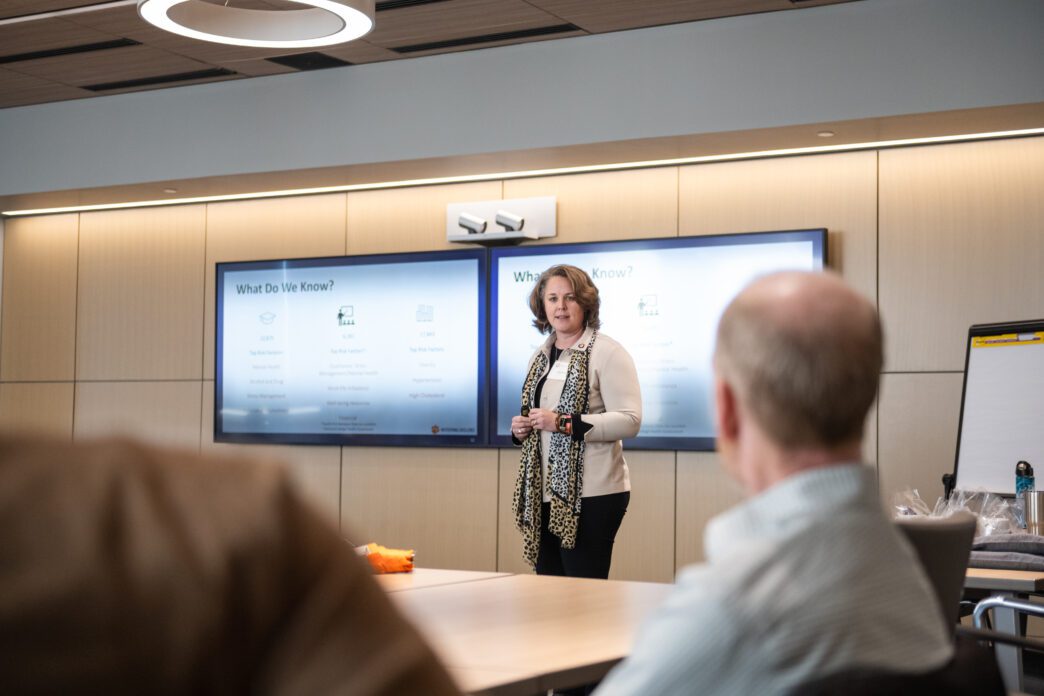 Anna Courie, chief well-being officer, speaks to a group in the College of Business board room