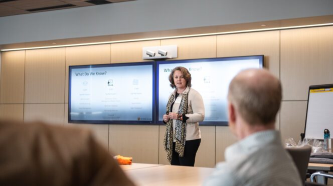 Anna Courie, chief well-being officer, speaks to a group in the College of Business board room