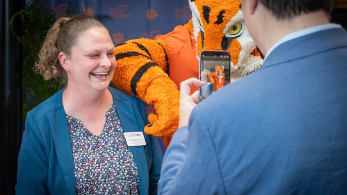 Rachel Anderson smiles for a photo with the Tiger mascot.