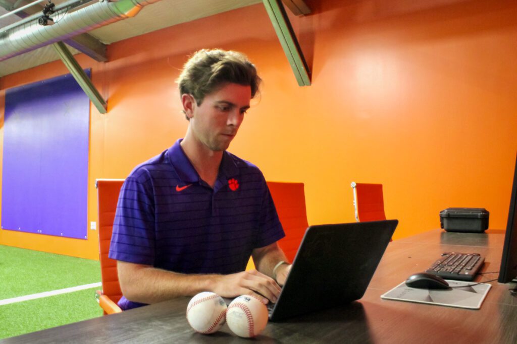 Student sitting at laptop in athletic facility
