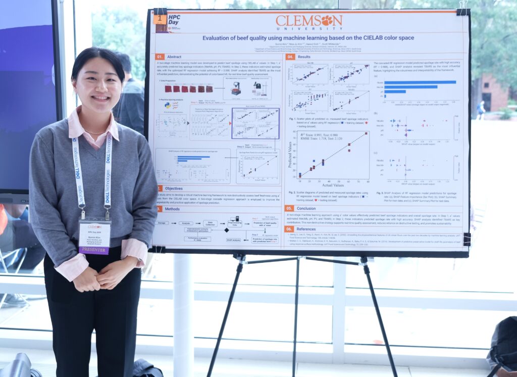 A Clemson student smiles in front of a research poster about HPC and beef quality. 