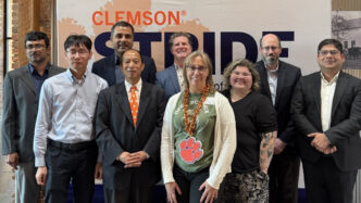 Members of the ART Academy post in front of a Clemson STRIDE sign.