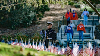 A student in Pershing Rifles looks out over the Scroll of Honor Memorial at Clemson University