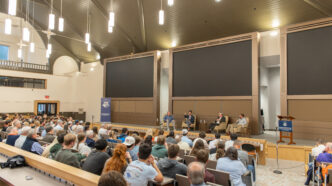 People sitting in lecture hall listening to a lecture.