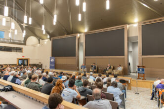 People sitting in lecture hall listening to a lecture.