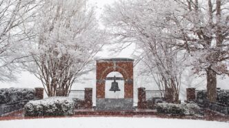 Heavy snow falling and covering trees and bushes during a winter storm on campus