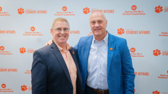 Vice President Doug Hallenbeck and President Jim Clements in front of a Division of Student Affairs backdrop