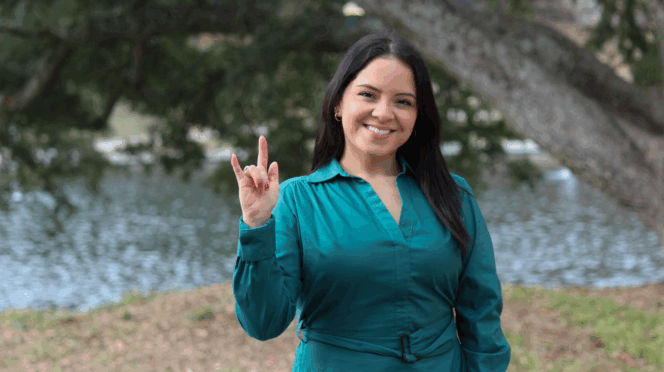 Senior American Sign Language major Jennifer Garcia holding up the sign for "love"