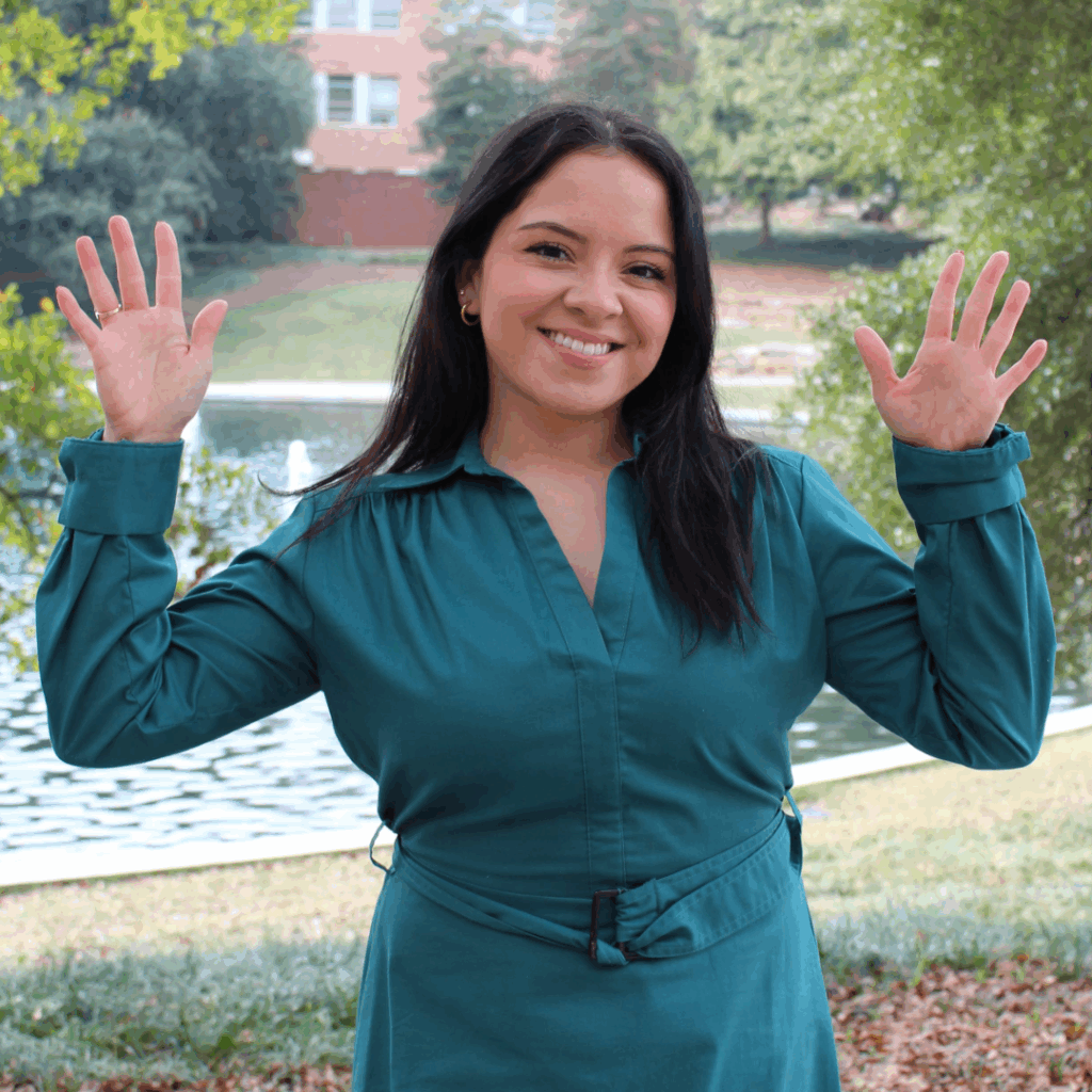Jennifer Garcia doing the sign for "hooray!" in American Sign Language.
