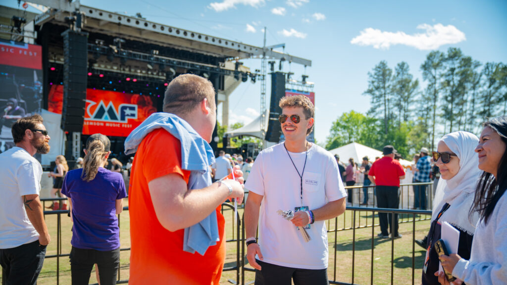 Two students speak in front of a stage at Clemson Music Fest