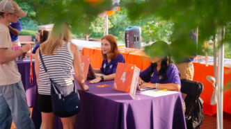 Lanier Ashley and another Orientation Ambassador check in students and families for Ready, Set, Roar! in-person Orientation in Summer 2025