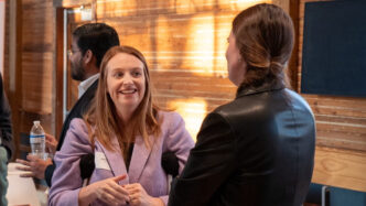 Two faculty members talk in the Barnes Center.