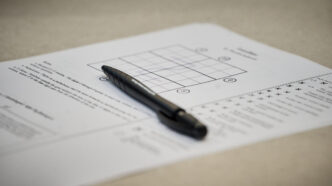 A back pen sits on top of a piece of paper with a sudoku puzzle