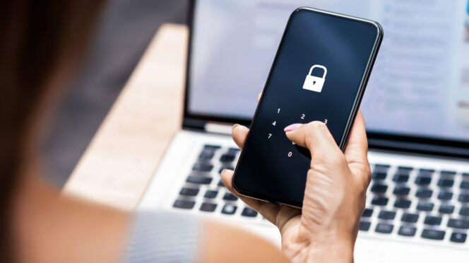 A woman types in a passcode on a phone with a lock icon displayed.