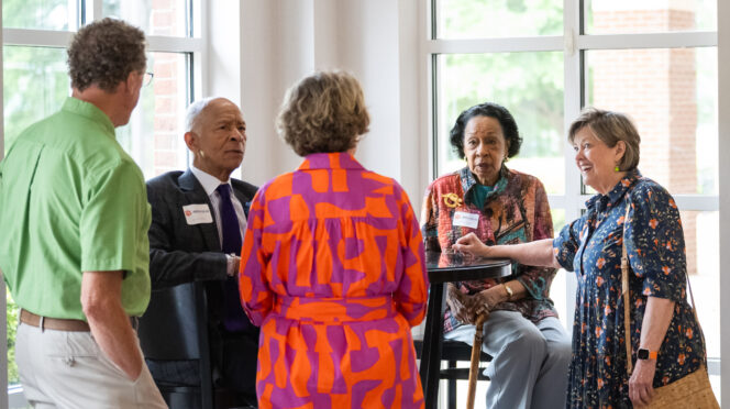 Emeritus Faculty chat around a table.