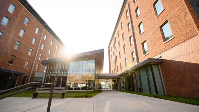 A view of the Clemson University Honors College from the front of the building, with the sun shining over the Great Hall.