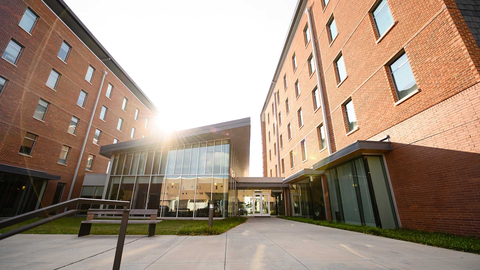 A view of the Clemson University Honors College from the front of the building, with the sun shining over the Great Hall.