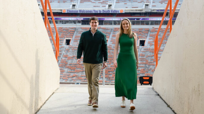 A male and female exit a portal inside of Memorial Stadium at Clemson University