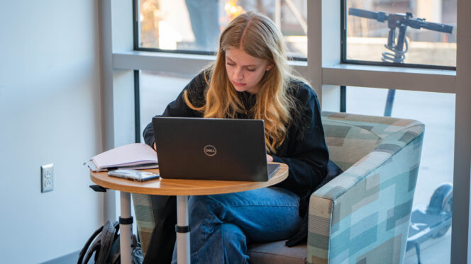 A student works on a laptop.