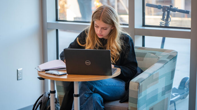 A student works on a laptop.