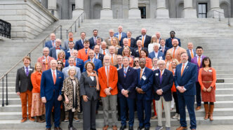 A group of individuals on the steps of the South Carolina State House in Clemson orange and purple