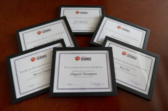 Photo of six framed certificates for the Clemson College of Science student award winners spread out on a table.