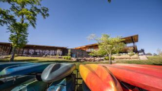 Kayaks and paddleboards in front of Andy Quattlebaum Outdoor Education Center
