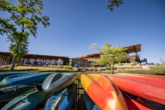 Kayaks and paddleboards in front of Andy Quattlebaum Outdoor Education Center