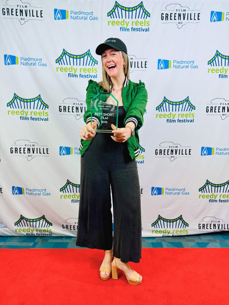 Teresa Catherine poses with an award on the red carpet at the Reedy River Film Festival