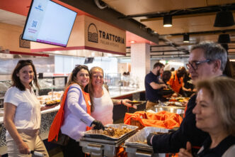 Two Clemson employees smiling while serving food.