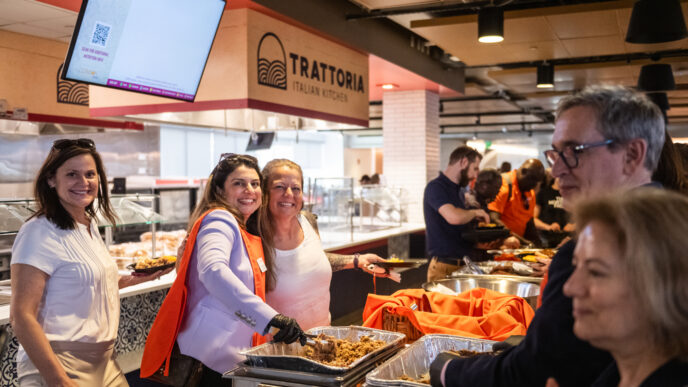Two Clemson employees smiling while serving food.