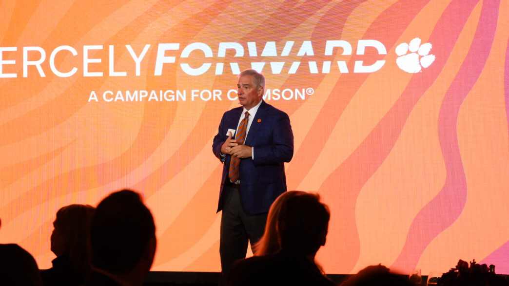 Brian O'Rourke, vice president of advancement, speaks in front of a digital screen