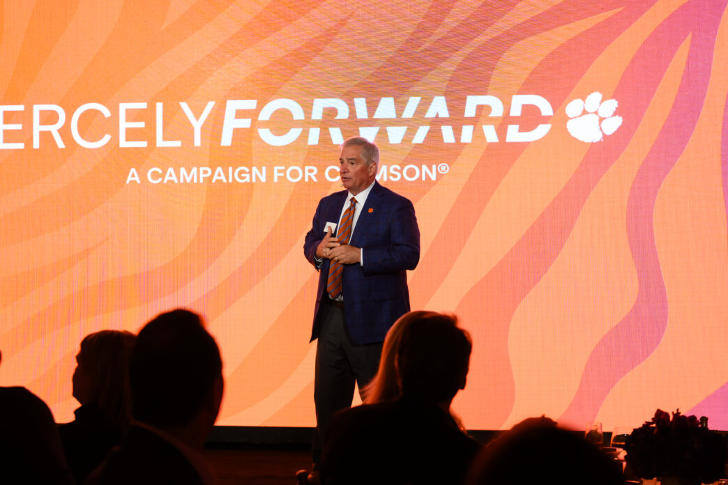 Brian O'Rourke, vice president of advancement, speaks in front of a digital screen