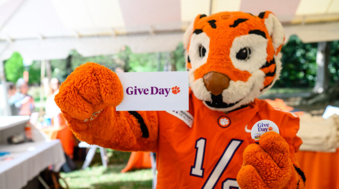 Tiger Cub mascot holds a card that reads 