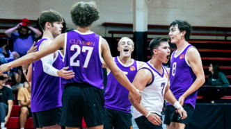 Male athletes in Clemson uniforms celebrate a point in a club volleyball match