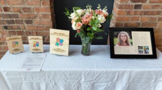 A table displaying flowers and a plaque in memory of Sarah A. Marshall, former program coordinator for peer-assisted learning at Clemson University