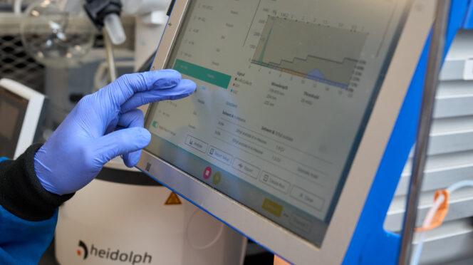 A gloved hand touches a computer screen