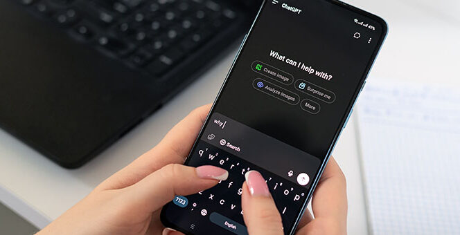Hands holding a smartphone and typing a prompt to ChatGPT