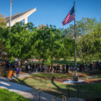 Attendees circle a large mound at the Scroll of Honor Memorial