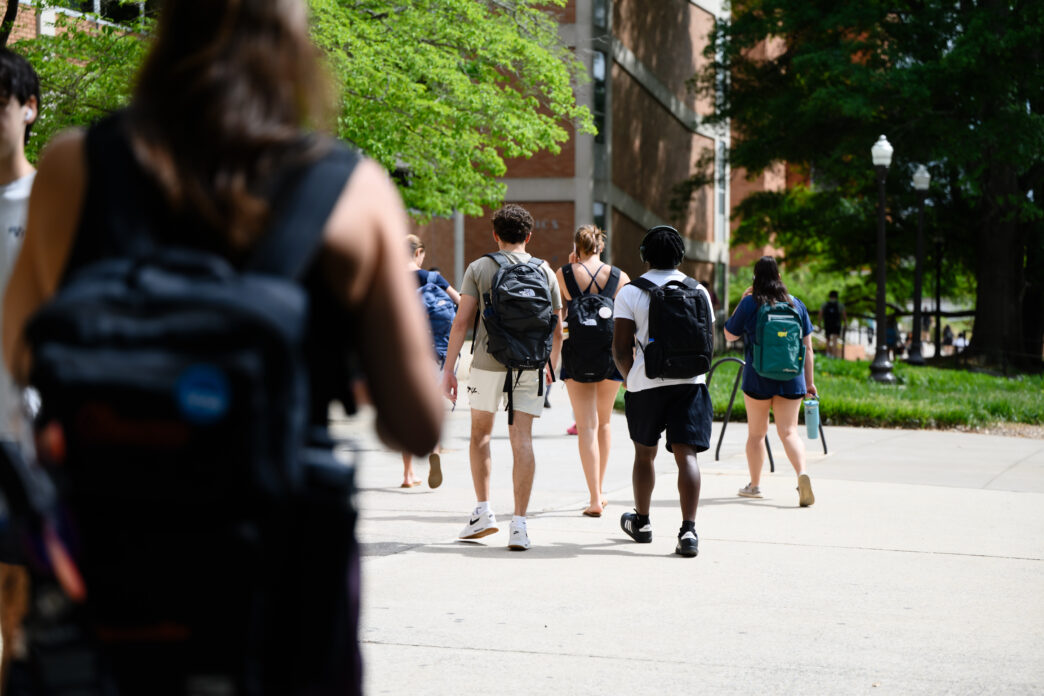 Students outdoors, walking away from the camera