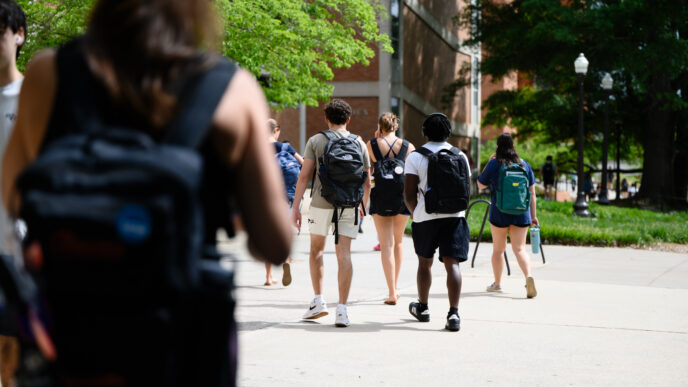 Students outdoors, walking away from the camera